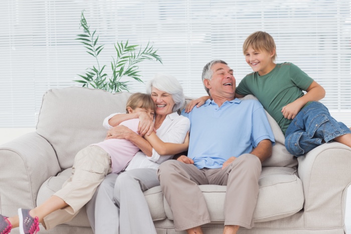 Happy elderly couple smiling with grandchildren
