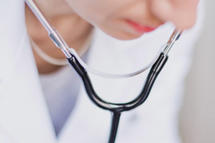 A Female Doctor using a stethoscope